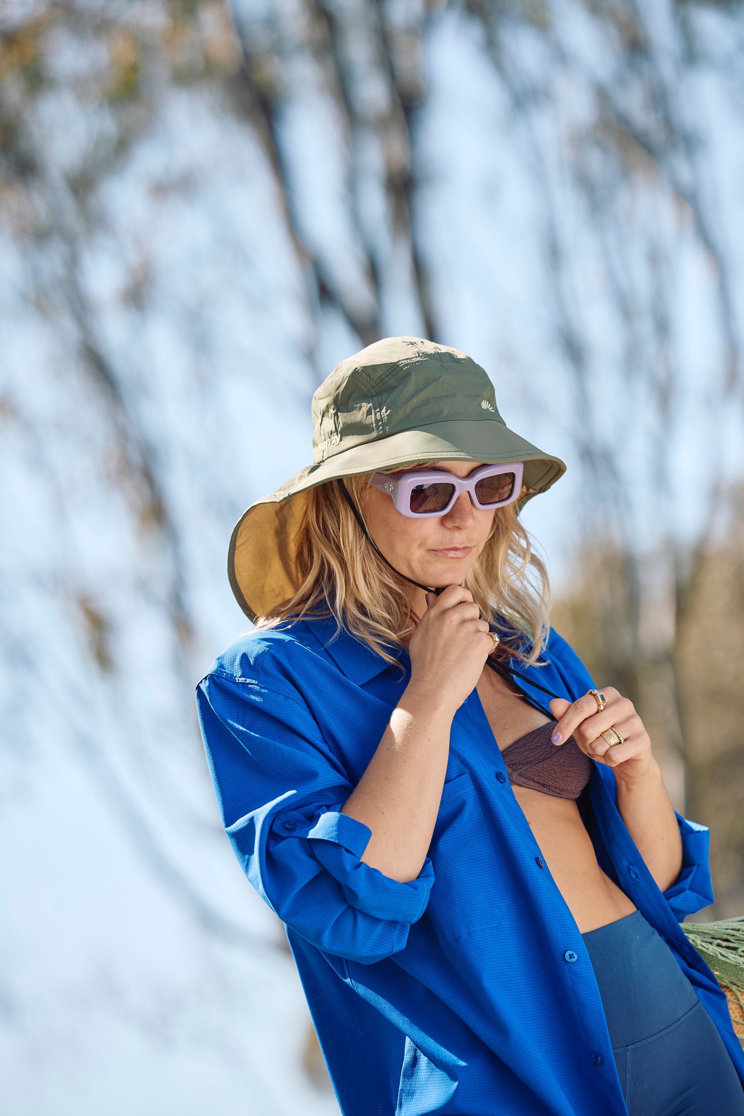 A sun smart woman wears the Sun Ray UPF50+ Sun Protection Clothing long sleeve shirt and mullet brimmer hat in Australia.