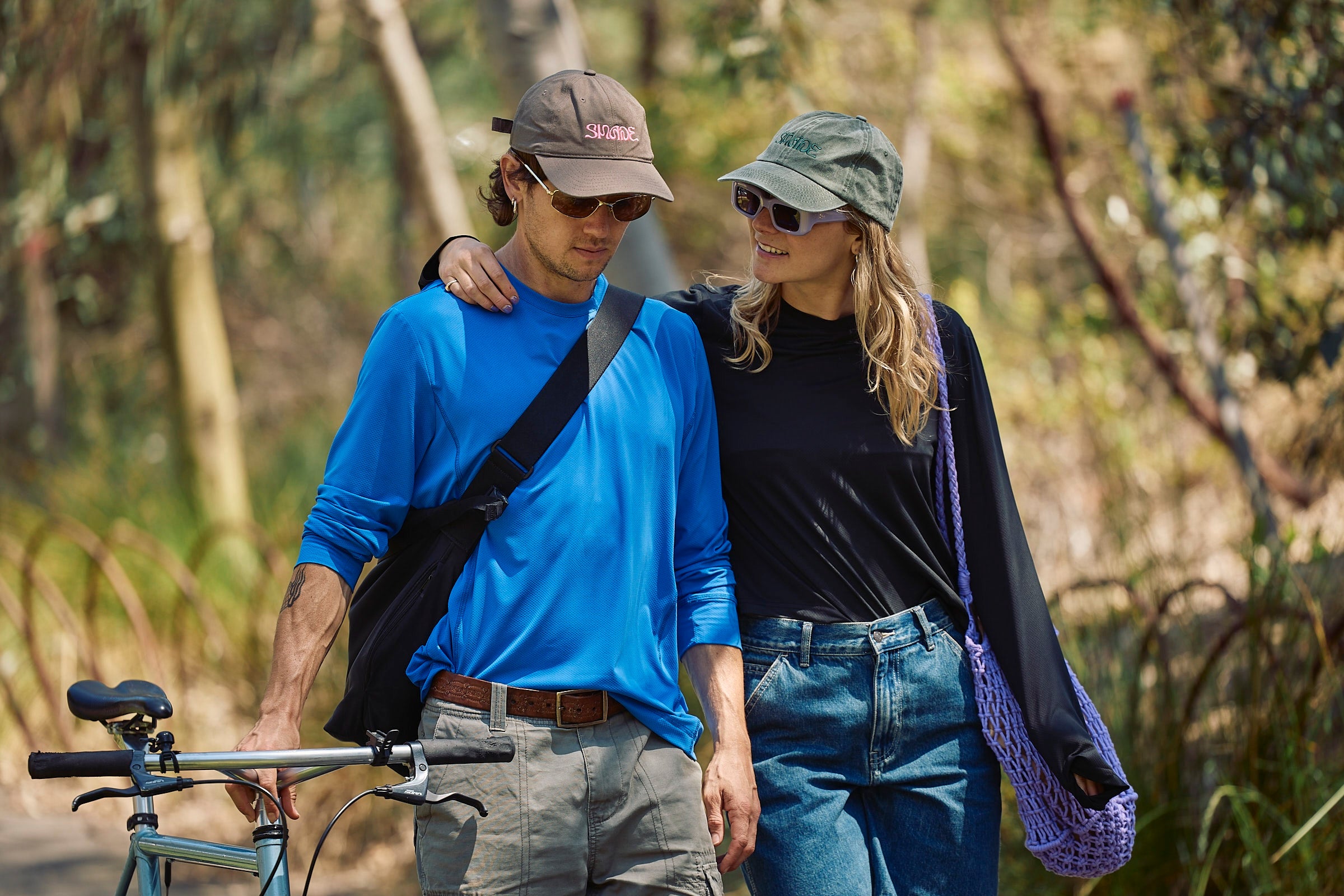 A sun smart couple wearing the Sun Ray UPF50+ Sun Protection Clothing All G Long Sleeve Tee true blue and black with Shade Cap in Australia.